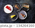 Assorted Cake Slices On Dark Slate Plates Create Colorful Dessert Display For Party 134264160