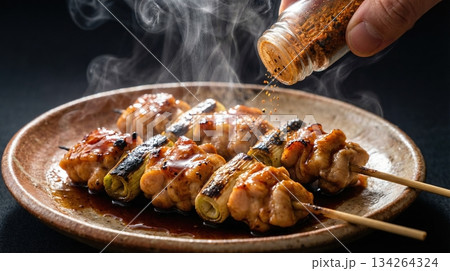 黒背景で引き立つ焼き鳥（ねぎま）と七味唐辛子 134264324