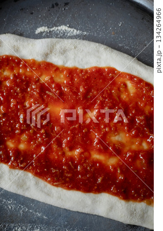 Spreading tomato sauce on pizza pan Spreading tomato sauce on pizza pan 134264966
