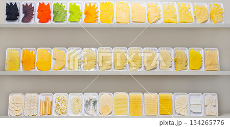 A row of trays with different colored food items on a shelf A row of trays with different colored food items on a shelf 134265776
