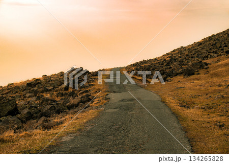 A road with a rocky hillside in the background 134265828