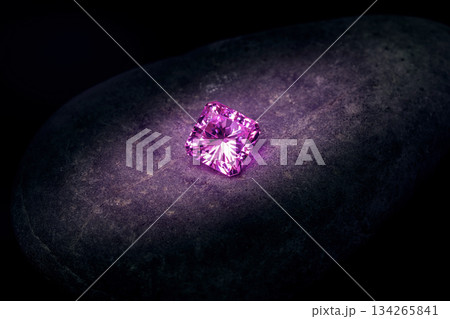 A small pink diamond is sitting on a rock A small pink diamond is sitting on a rock 134265841