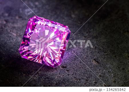 A large purple diamond is sitting on a grey surface A large purple diamond is sitting on a grey surface 134265842