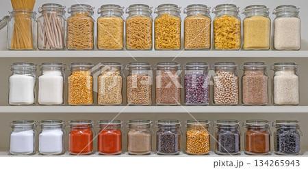 A shelf full of glass jars containing various spices and grains A shelf full of glass jars containing various spices and grains 134265943