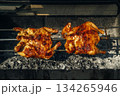 Two pieces of chicken are being cooked on a grill 134265946