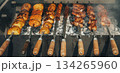 A grill with skewers of meat and potatoes on it 134265960