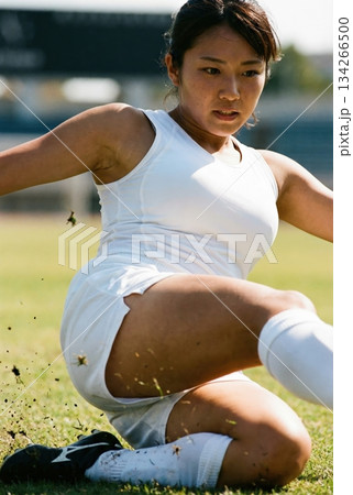 激しいスライディングでボールを奪いに行く女子サッカー選手 134266500