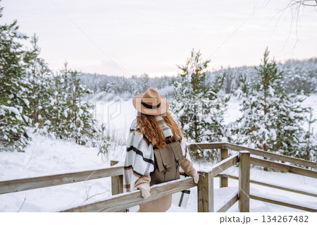 Woman traveler in a hat with a backpack on a wooden ladder. Active lifestyle. Travel concept. Woman traveler in a hat with a backpack on a wooden ladder. Active lifestyle. Travel concept. 134267482