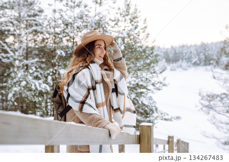 Woman traveler in a hat with a backpack on a wooden ladder. Active lifestyle. Travel concept. 134267483