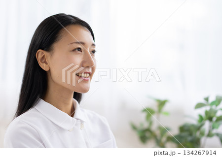 窓際で笑顔を見せる白衣姿の女性 窓際で笑顔を見せる白衣姿の女性 134267914