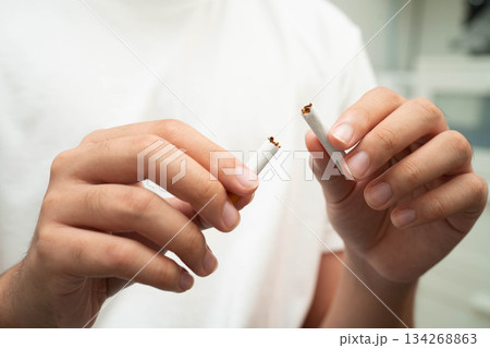 Quit smoking, Asian teenage man breaking destroy cigarette in hand. 134268863