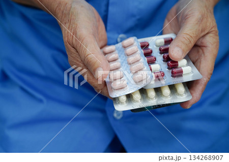 Asian elderly woman holding pill drug in hand, strong healthy medical. 134268907