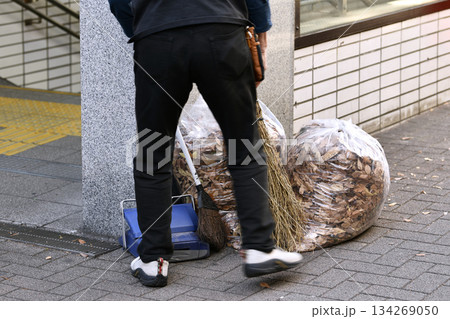 日本の横浜都市景観 師走…高齢化社会 落葉掃除をする高齢男性…高齢でも働かなければならない社会とは… 134269050