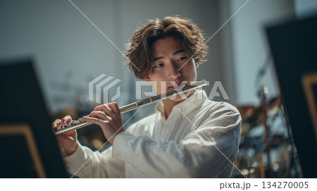 音楽の夢を追いながら教室でフルートの練習に励む若い演奏家 134270005