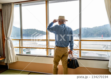 窓から海と島を眺める旅行者 134270194