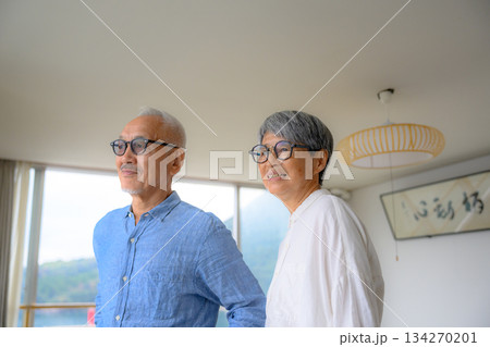 窓辺で外を眺める老夫婦 134270201