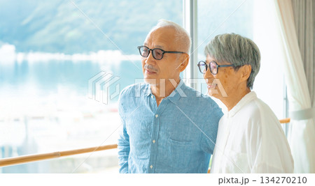 窓から外を眺める老夫婦 134270210