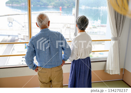 窓から海を眺めるシニア夫婦 窓から海を眺めるシニア夫婦 134270237