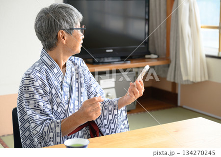 浴衣のシニアがスマホを見る様子 134270245