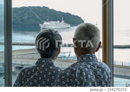 窓から海と船を眺める老夫婦 134270253