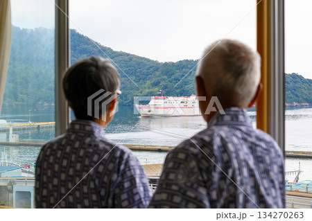 窓からフェリーと島を眺める老夫婦 134270263