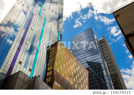 Modern buildings stand tall against with clouds in busy Manhattan skyline, city 134270315