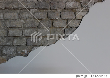 An uneven edge separates the plastered section of the wall from the rough brickwork. Wall finishing materials stock photo An uneven edge separates the plastered section of the wall from the rough brickwork. Wall finishing materials stock photo 134270453