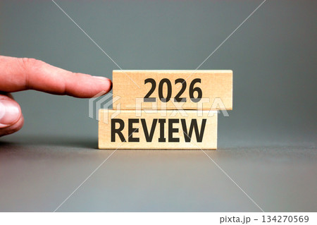 2026 Review symbol. Concept words 2026 Review on beautiful wooden blocks. Beautiful grey paper background. Businessman's hand. Business and 2026 review concept. Copy space. 2026 Review symbol. Concept words 2026 Review on beautiful wooden blocks. Beautiful grey paper background. Businessman's hand. Business and 2026 review concept. Copy space. 134270569