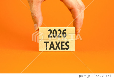 2026 taxes new year symbol. Concept words 2026 taxes on beautiful wooden blocks. Beautiful orange paper background. Businessman's hand. Business and 2026 taxes new year concept. Copy space. 2026 taxes new year symbol. Concept words 2026 taxes on beautiful wooden blocks. Beautiful orange paper background. Businessman's hand. Business and 2026 taxes new year concept. Copy space. 134270571