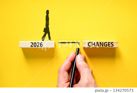 2026 Changes symbol. Concept words 2026 Changes on beautiful wooden blocks. Beautiful yellow background. Businessman holds pencil. Businesswoman icon. Business and 2026 changes concept. Copy space. 134270573