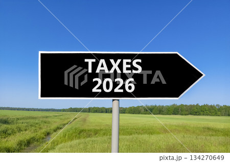 Taxes 2026 new year symbol. Concept words Taxes 2026 on beautiful black road sign. Beautiful green grass field forest and blue sky background. Business and taxes 2026 new year concept. Copy space. Taxes 2026 new year symbol. Concept words Taxes 2026 on beautiful black road sign. Beautiful green grass field forest and blue sky background. Business and taxes 2026 new year concept. Copy space. 134270649