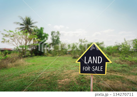 land for sale sign against trimmed lawn background. Empty dry cracked swamp reclamation soil, land plot for housing construction project land for sale sign against trimmed lawn background. Empty dry cracked swamp reclamation soil, land plot for housing construction project 134270711