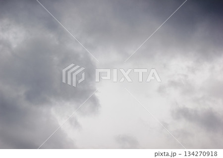 A dramatic and moody sky filled with thick, dark grey storm clouds creating a textured background 134270918