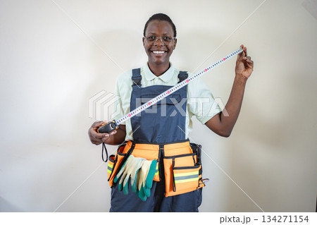 Smiling african american craftswoman holding measuring tape and looking at camera 134271154