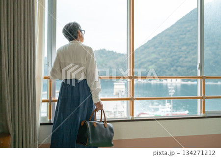 窓から外の景色を眺める高齢女性 134271212