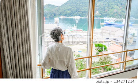 窓から海を眺める高齢女性の後ろ姿 窓から海を眺める高齢女性の後ろ姿 134271214