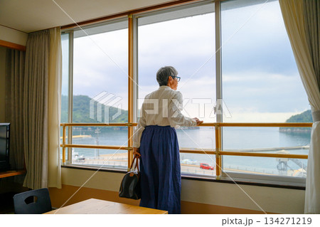 窓から海を眺める年配女性 134271219