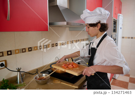 Chef In White Hat Chops Tomatoes On Cutting Board In Modern Red Kitchen 134271463