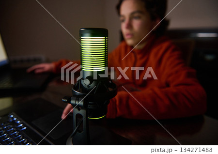 Microphone Studio Setup With Green Glow On Microphone and Blurred Person at Desk Microphone Studio Setup With Green Glow On Microphone and Blurred Person at Desk 134271488