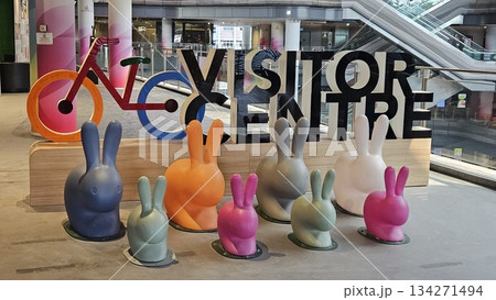 A vibrant visitor centre display with colorful rabbits, a stylized bicycle, and gradient pillars creates a playful, 134271494