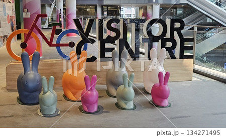 A vibrant visitor centre display with colorful rabbits, a stylized bicycle, and gradient pillars creates a playful, 134271495