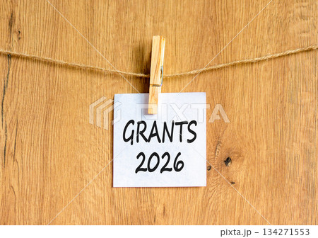 Grants 2026 symbol. Concept words Grants 2026 on beautiful white paper on wooden clothespin. Beautiful wooden background. Business and grants 2026 concept. Copy space. Grants 2026 symbol. Concept words Grants 2026 on beautiful white paper on wooden clothespin. Beautiful wooden background. Business and grants 2026 concept. Copy space. 134271553