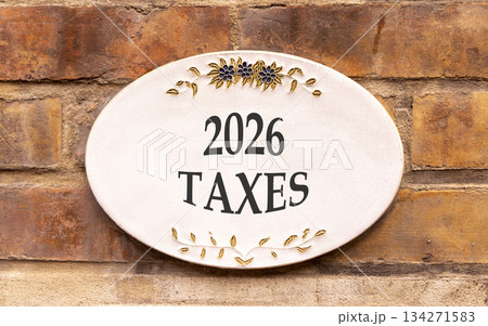 2026 taxes new year symbol. Concept words 2026 taxes on beautiful white sign. Beautiful old brown brick wall background. Business and 2026 taxes new year concept. Copy space. 134271583
