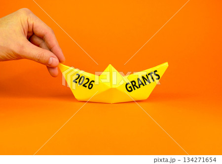 2026 Grants symbol. Concept words 2026 Grants on beautiful yellow paper boat. Beautiful orange paper background. Businessman's hand. Business and 2026 grants concept. Copy space. 2026 Grants symbol. Concept words 2026 Grants on beautiful yellow paper boat. Beautiful orange paper background. Businessman's hand. Business and 2026 grants concept. Copy space. 134271654