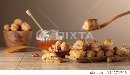 Baklava with walnuts and honey on a beige background. 134271746