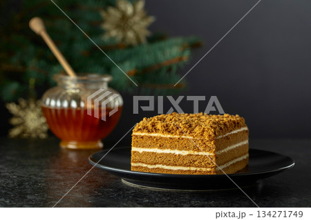 Layered honey cake on a background of Christmas tree. 134271749