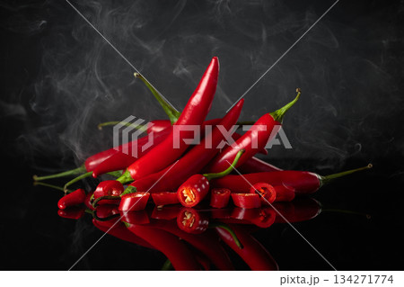 Fresh red chili peppers on a black reflective background. 134271774