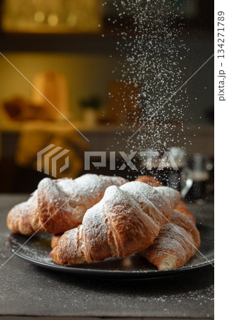 Croissants sprinkled with sugar powder. 134271789