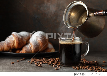 Croissants and black coffee on a kitchen table. Croissants and black coffee on a kitchen table. 134271790
