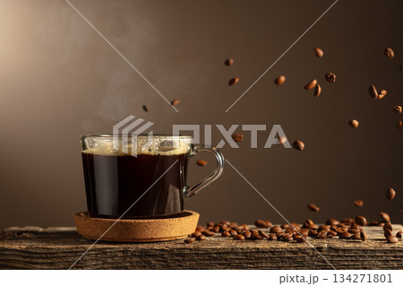 Black coffee in glass cup on an old wooden board. Black coffee in glass cup on an old wooden board. 134271801